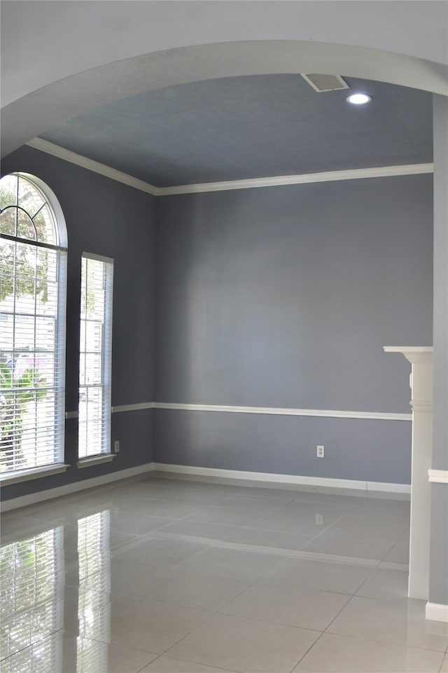 tiled empty room featuring crown molding