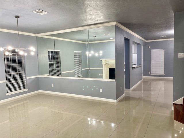 tiled spare room with a textured ceiling, crown molding, and a tile fireplace