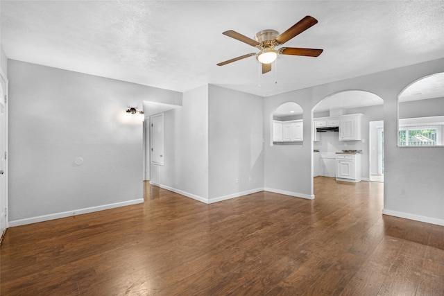 empty room featuring a textured ceiling, dark hardwood / wood-style flooring, and ceiling fan