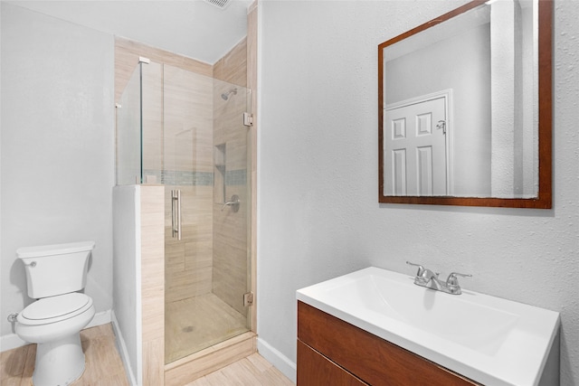 bathroom featuring hardwood / wood-style flooring, vanity, toilet, and an enclosed shower