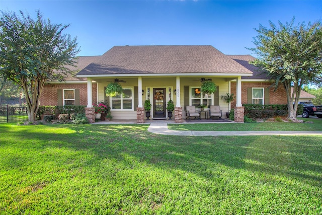 view of front facade featuring a front yard, ceiling fan, and covered porch