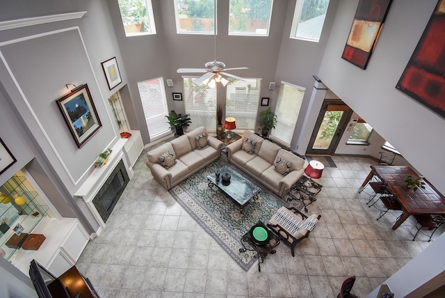 living room featuring a towering ceiling, plenty of natural light, and ceiling fan