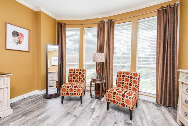 sitting room with ornamental molding and light hardwood / wood-style floors