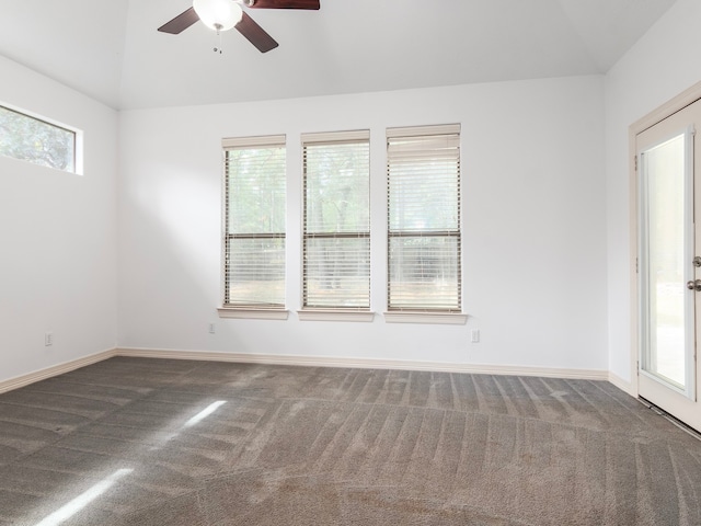 spare room with ceiling fan, vaulted ceiling, and dark carpet