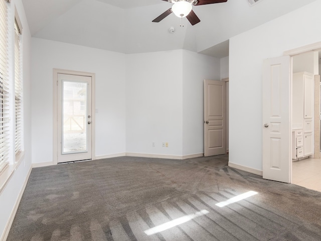 empty room featuring vaulted ceiling, light colored carpet, and ceiling fan