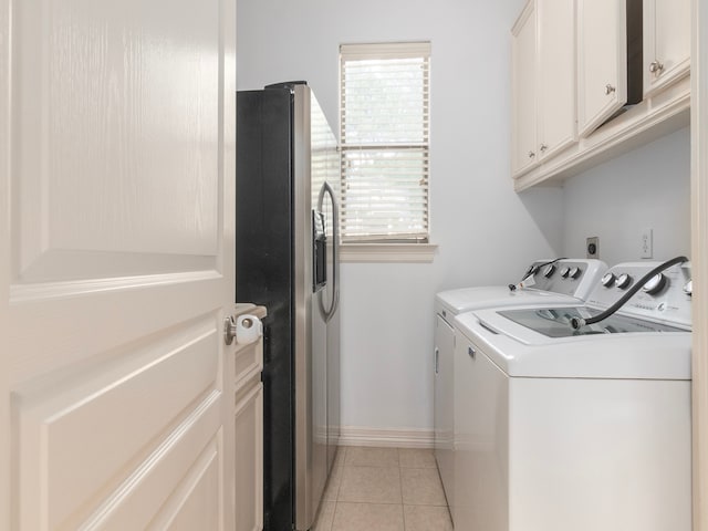 washroom with cabinets, washer and clothes dryer, and light tile patterned floors