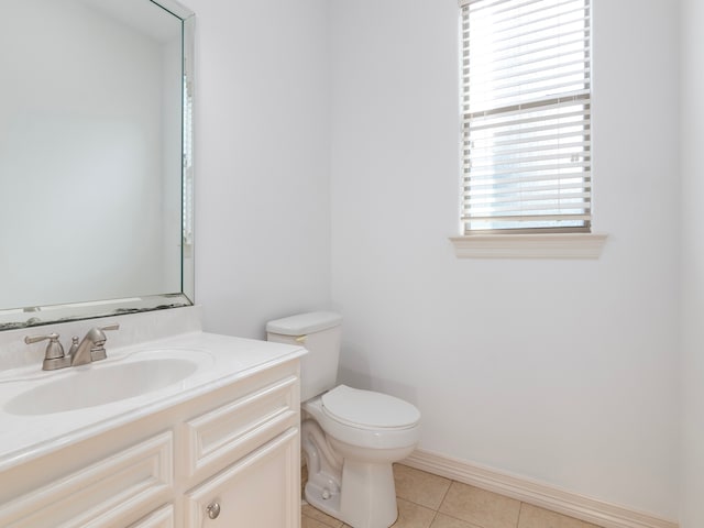 bathroom with toilet, vanity, and tile patterned floors