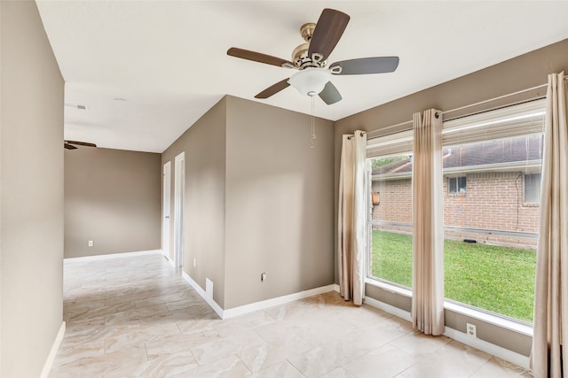 unfurnished room with ceiling fan and a healthy amount of sunlight