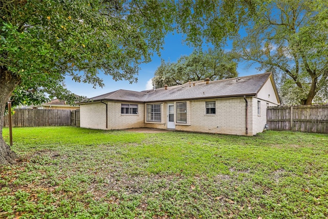 back of property featuring a lawn and a patio