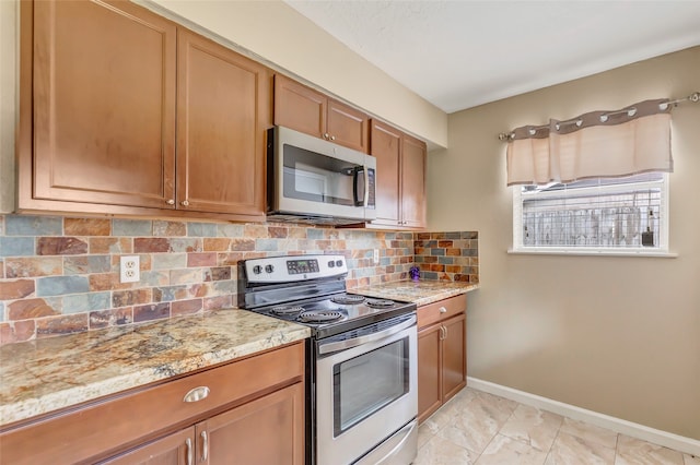 kitchen with tasteful backsplash, light stone counters, and stainless steel appliances