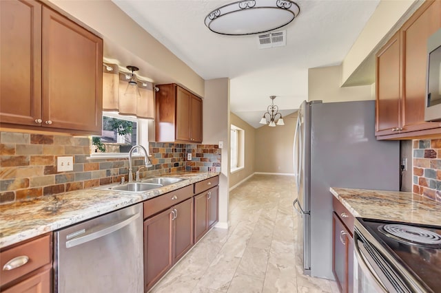 kitchen featuring stainless steel appliances, sink, light stone countertops, an inviting chandelier, and decorative backsplash