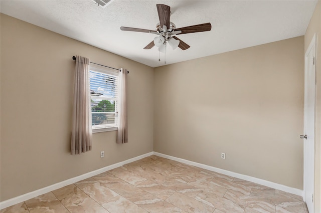 empty room with ceiling fan and a textured ceiling