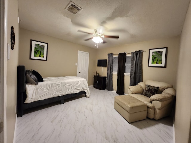 bedroom with ceiling fan and a textured ceiling