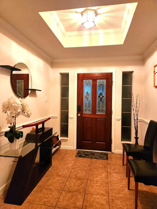 tiled foyer entrance with a tray ceiling and crown molding