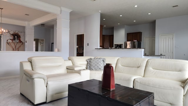 living room featuring a chandelier and decorative columns