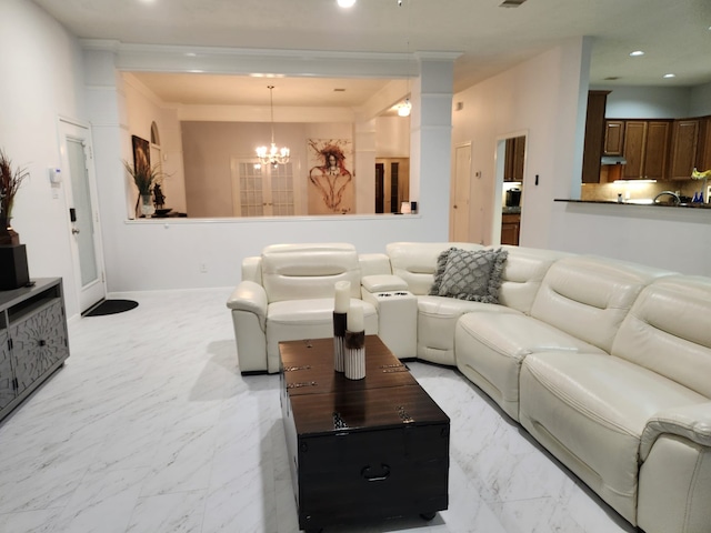 living room with crown molding and an inviting chandelier