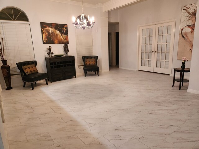 living area with crown molding, french doors, and a chandelier