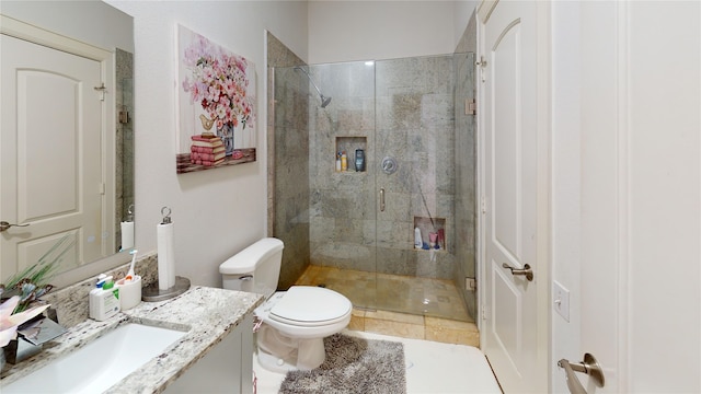 bathroom featuring tile patterned floors, vanity, an enclosed shower, and toilet