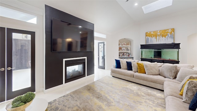 living room featuring french doors, lofted ceiling with skylight, a fireplace, and built in features