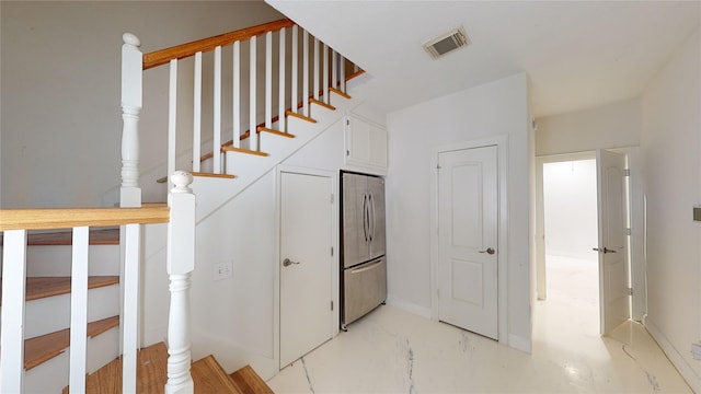 staircase with baseboards and visible vents