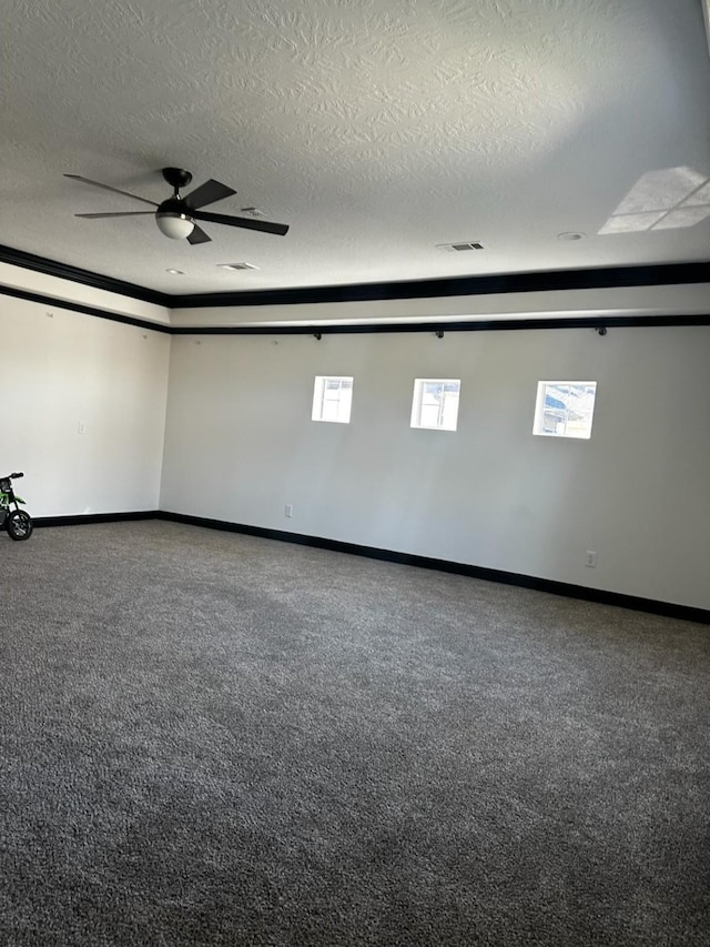 unfurnished room featuring baseboards, carpet, ceiling fan, and a textured ceiling