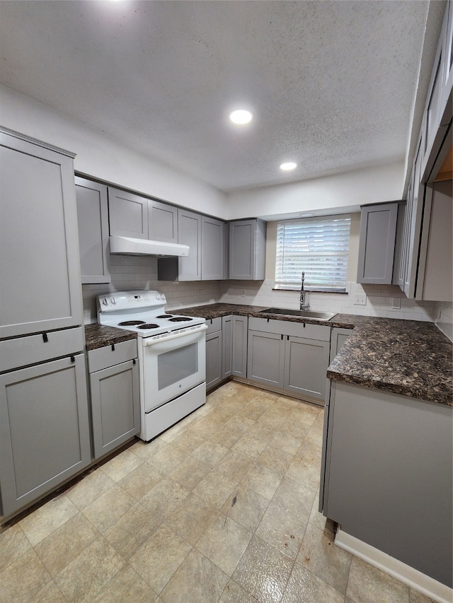 kitchen with gray cabinets, decorative backsplash, sink, and electric stove