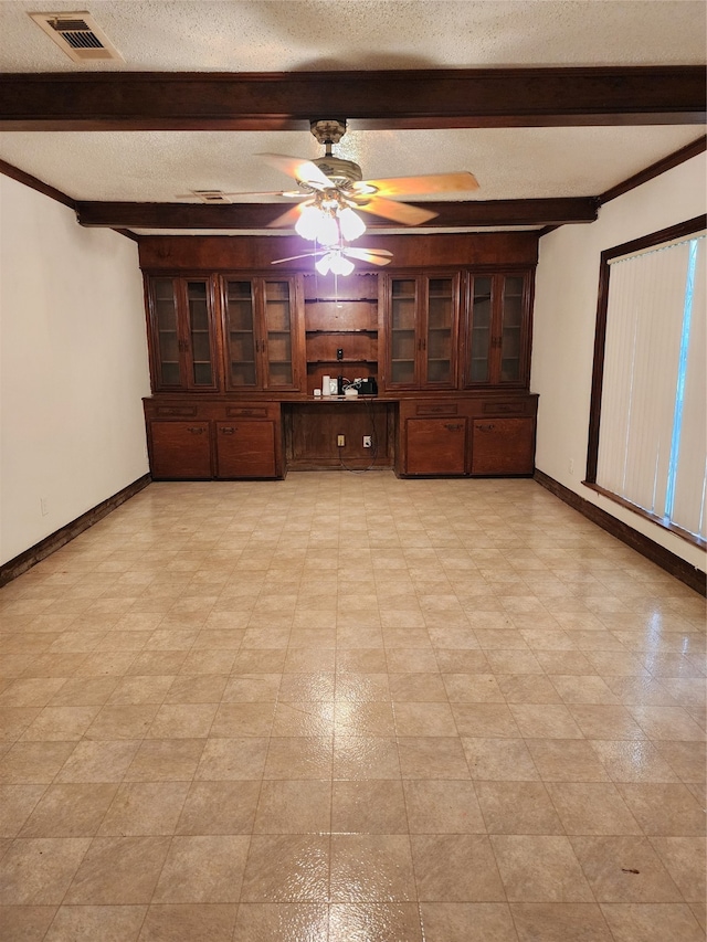 empty room with a textured ceiling, ceiling fan, and beam ceiling