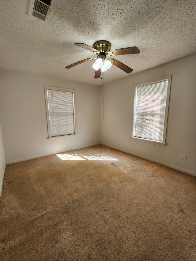 carpeted empty room with a textured ceiling and ceiling fan