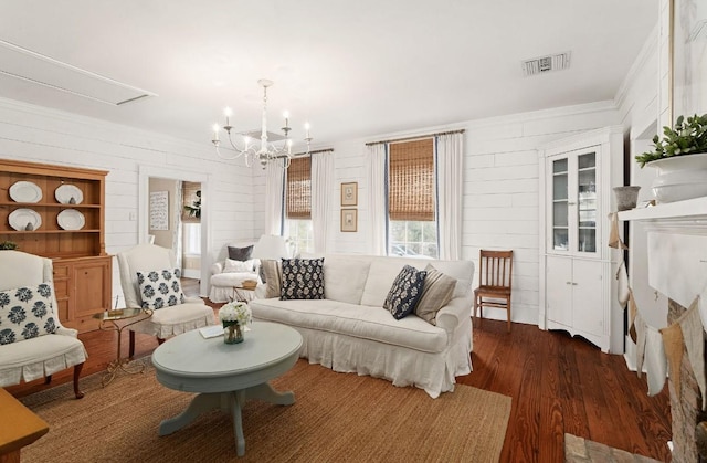 living area with a notable chandelier, visible vents, and wood finished floors