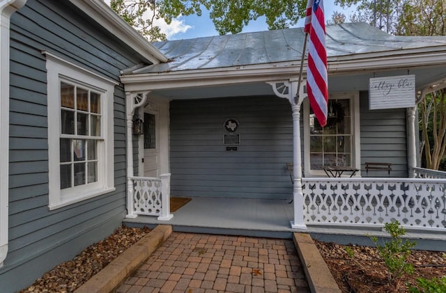 view of exterior entry featuring covered porch