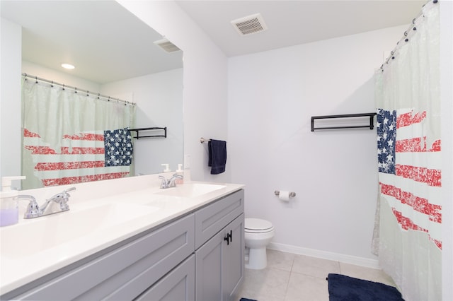 bathroom with toilet, vanity, and tile patterned floors