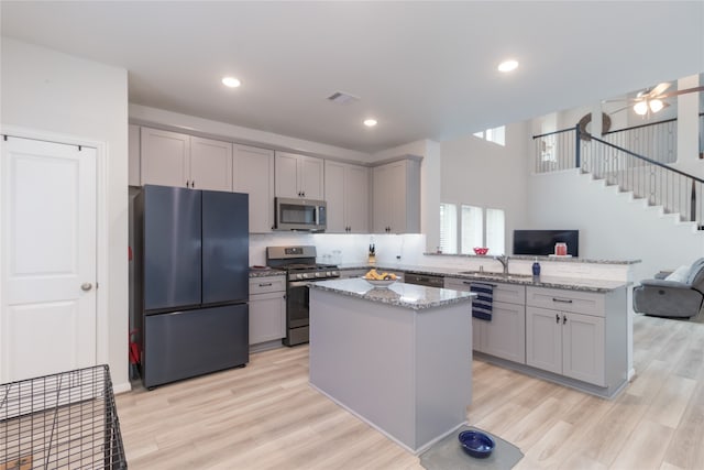 kitchen featuring gray cabinets, appliances with stainless steel finishes, and light wood-type flooring