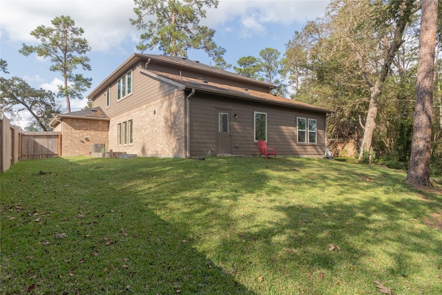 back of property featuring central AC unit and a lawn