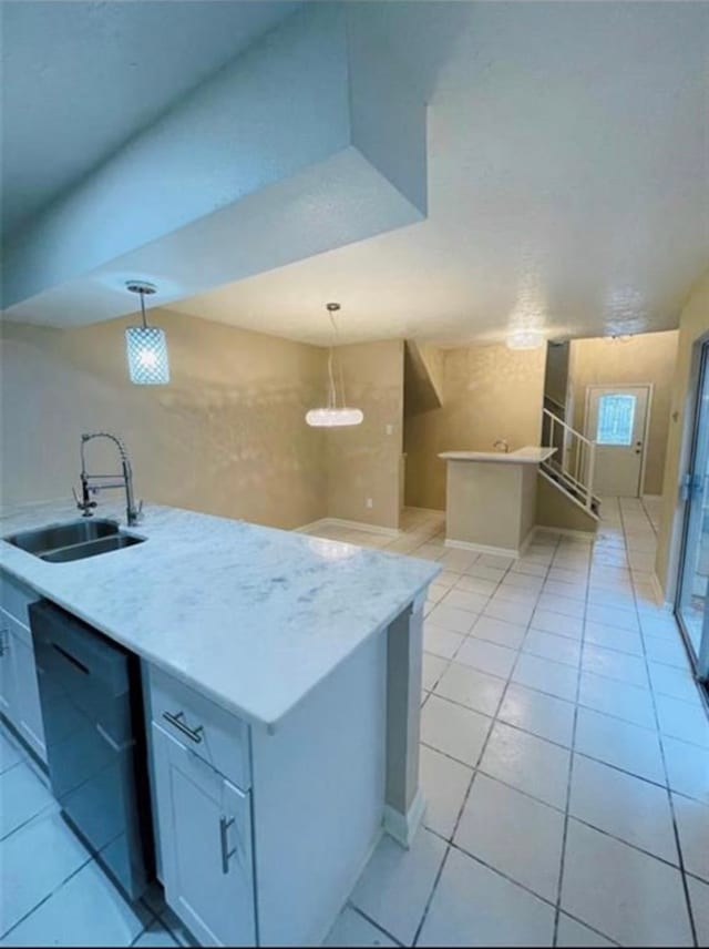 kitchen featuring pendant lighting, black dishwasher, sink, and light tile patterned floors