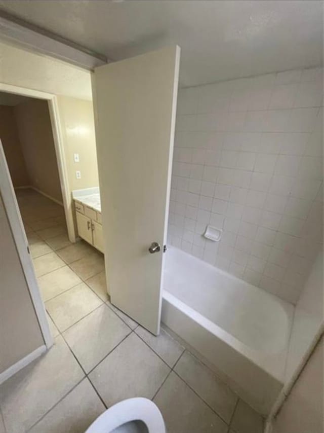 full bathroom featuring vanity, tile patterned flooring, toilet, and tiled shower / bath