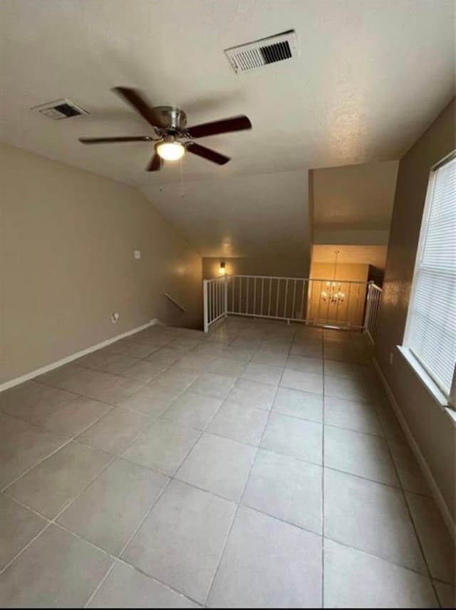 spare room with ceiling fan, light tile patterned floors, and lofted ceiling