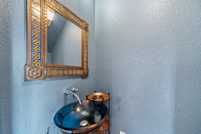 1174 Highland Terrace Dr, Canyon Lake, TX 78133 - bathroom with a sink, vaulted ceiling, and a textured wall