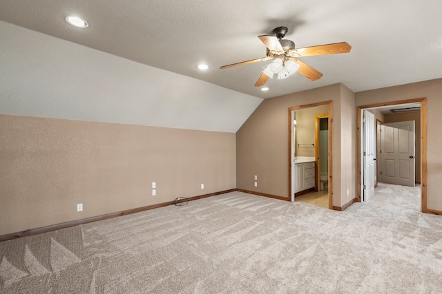 additional living space featuring lofted ceiling, ceiling fan, a textured ceiling, light carpet, and baseboards