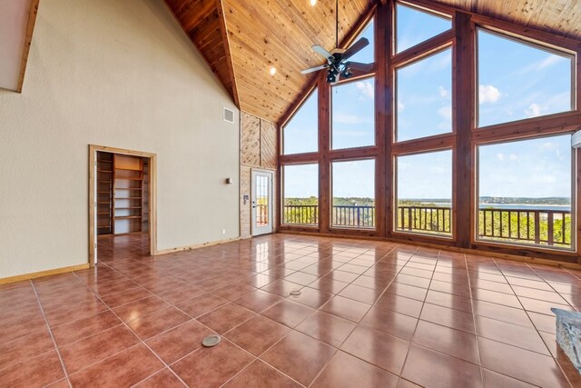 interior space featuring a ceiling fan, lofted ceiling, wood ceiling, and plenty of natural light