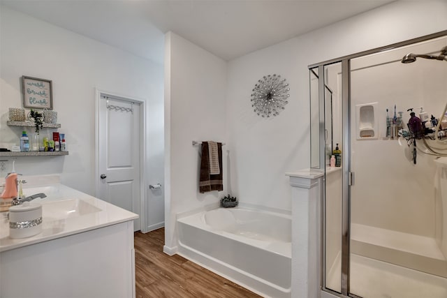 bathroom featuring hardwood / wood-style floors, vanity, and plus walk in shower