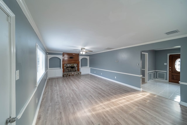 unfurnished living room with a fireplace, light hardwood / wood-style flooring, ceiling fan, and ornamental molding