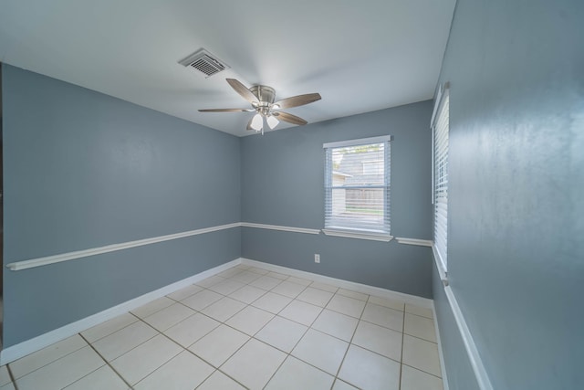 tiled spare room featuring ceiling fan