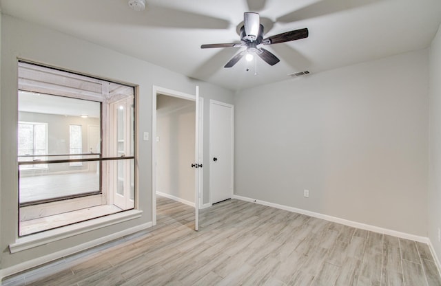 unfurnished bedroom with baseboards, visible vents, ceiling fan, and wood finished floors