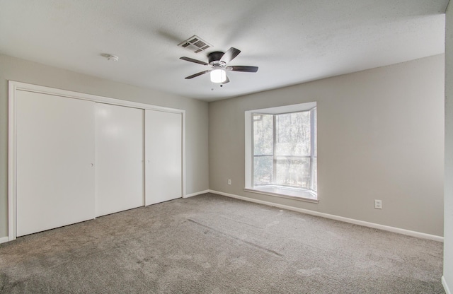 unfurnished bedroom featuring a closet, carpet, visible vents, and baseboards