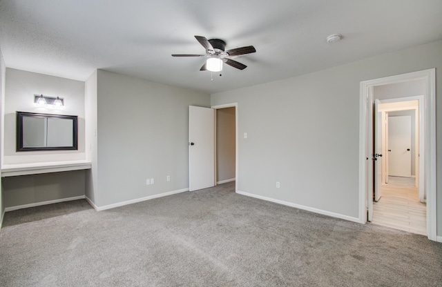 unfurnished bedroom featuring carpet floors, baseboards, and a ceiling fan