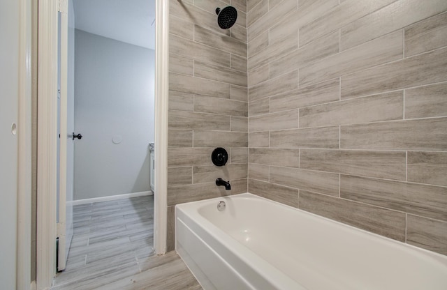 bathroom with bathtub / shower combination and baseboards