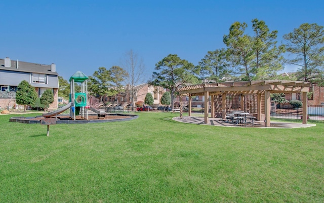 view of yard featuring playground community, fence, and a pergola