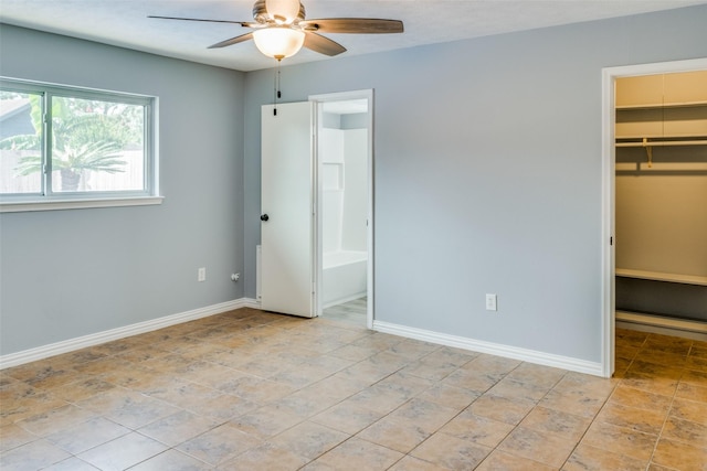 unfurnished bedroom with ceiling fan, a walk in closet, ensuite bathroom, and a closet