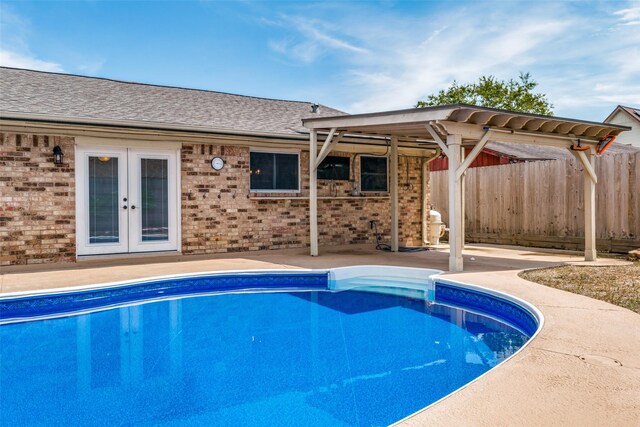 view of swimming pool featuring a patio and french doors