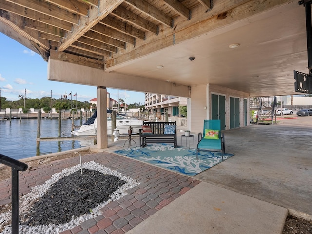 view of patio / terrace with a water view, an outdoor fire pit, and a boat dock